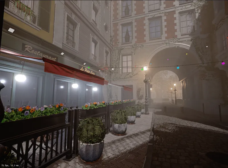 A foggy cobbled street with a restaurant terrace, flower boxes and strings of coloured lights
